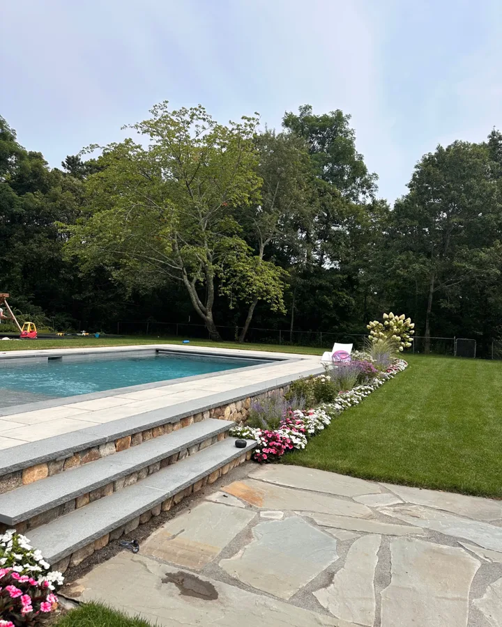 Stone pool steps framed by flowering plants